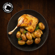 Cuisse de canard confite fondante accompagnée de pommes de terre rôties.